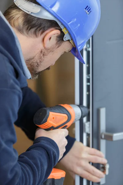 Homem Repara Uma Porta Com Broca Elétrica — Fotografia de Stock