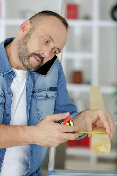 Middle Aged Man Measures Wooden Bar — Stock Photo, Image