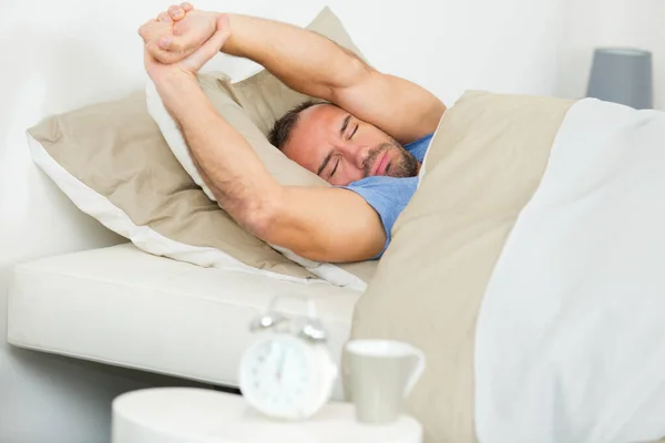 Mann Bett Streckt Arme Über Den Kopf — Stockfoto