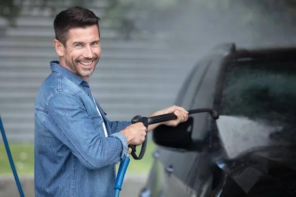 Een Man Wast Een Auto Met Een Slang — Stockfoto