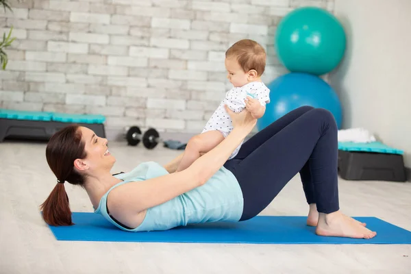 Kadın Yerde Bebekle Egzersiz Yapıyor — Stok fotoğraf