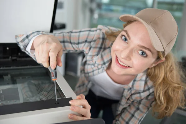 快乐的年轻女子正在修理复印机 — 图库照片
