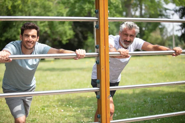 Two Concentrated Sportsmen Working Out Bars Outdoors — Stock Photo, Image