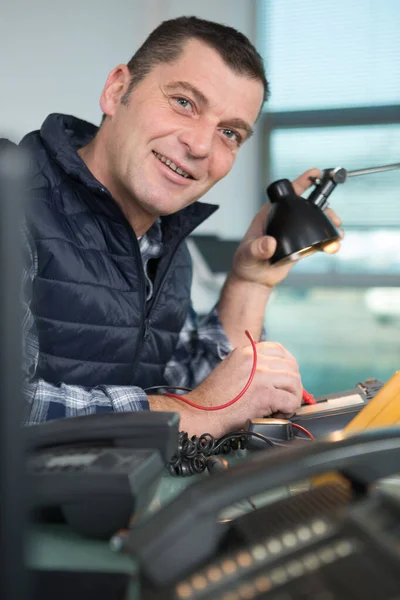 快乐的计算机工程师在破碎的控制台上工作 — 图库照片
