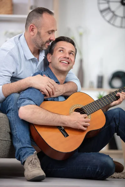 Gay Coppia Con Chitarra Seduta Divano Casa — Foto Stock