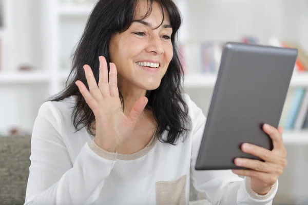 美丽成熟的女人在平板电脑前挥手微笑 — 图库照片