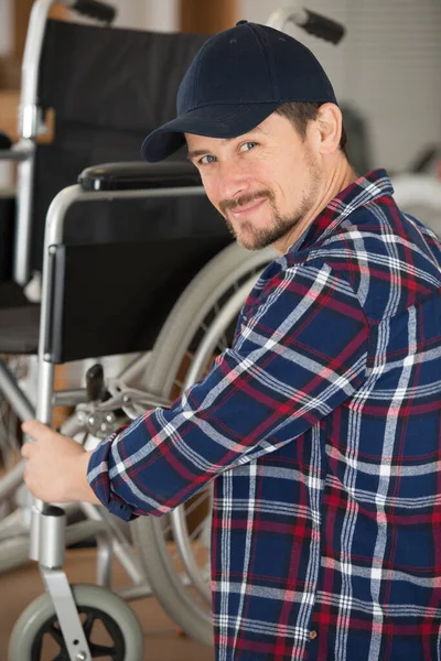 Mężczyzna Naprawia Wózek Inwalidzki Warsztacie — Zdjęcie stockowe
