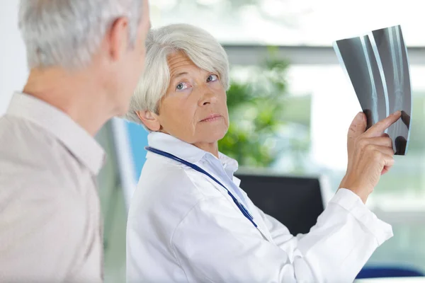 Olgun Bir Kadın Doktor Röntgene Bakıyor — Stok fotoğraf