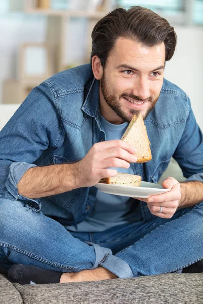 Молодий Дорослий Чоловік Їсть Бутерброд Вдома — стокове фото
