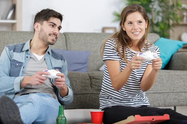 夫妻在沙发上使用电子游戏控制器微笑 — 图库照片