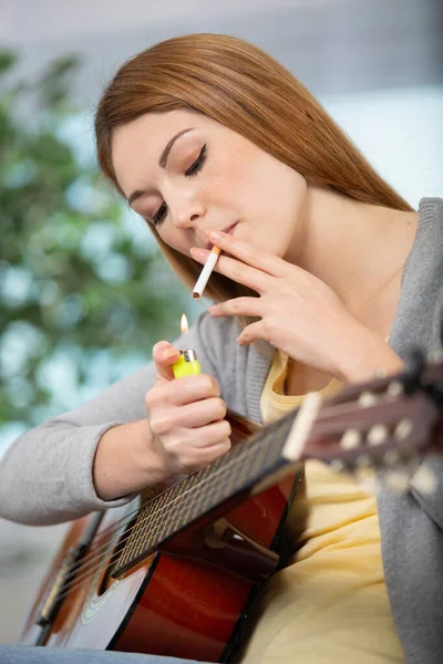 Γυναίκα Καπνίζει Ένα Τσιγάρο Ενώ Παίζει Κιθάρα — Φωτογραφία Αρχείου