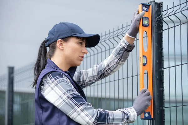 Vrouw Gebouw Hek Controleren Met Waterpas — Stockfoto