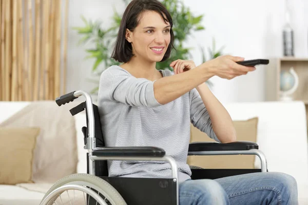 Žena Invalidním Vozíku Používá Dálkové Ovládání Televize — Stock fotografie