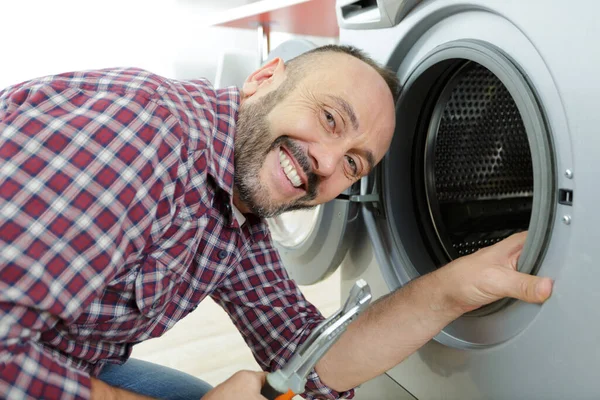 Homem Feliz Repara Uma Máquina Lavar Roupa Lavanderia — Fotografia de Stock