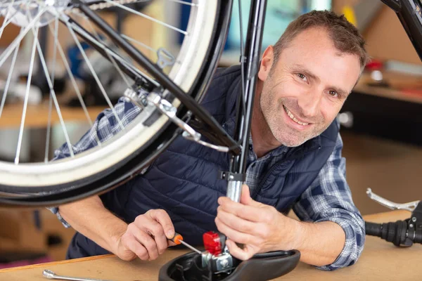 プロのメカニックがモダンなワーク ショップで自転車を修理 — ストック写真