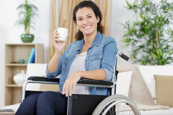 室内でコーヒーを飲みながら車椅子の若い女性 — ストック写真