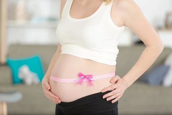 妊娠中の女性にピンクリボンをつけて — ストック写真