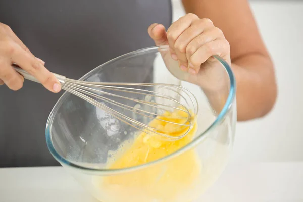 女厨师在碗里用金属丝搅拌鸡蛋 — 图库照片