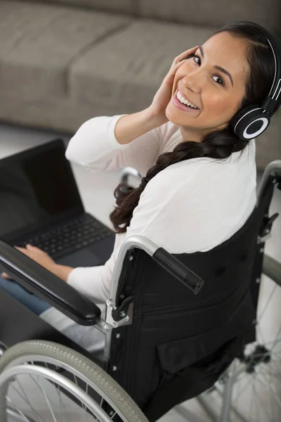 Γυναίκα Αναπηρική Καρέκλα Φορώντας Ακουστικά Και Χρησιμοποιώντας Ένα Φορητό Υπολογιστή — Φωτογραφία Αρχείου