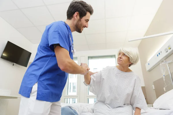Krankenschwester Hilft Älteren Patienten Aus Dem Krankenhausbett — Stockfoto