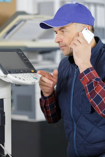 Techniker Sucht Hilfe Telefon Während Drucker Repariert — Stockfoto