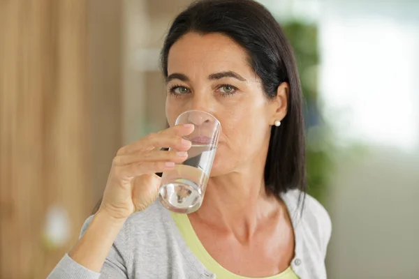 Mujer Bebe Agua Casa — Foto de Stock