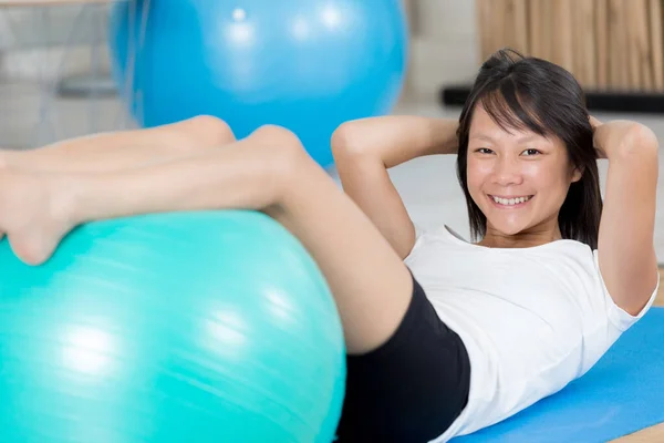 令人愉快的运动型女人坐在橡胶球 — 图库照片