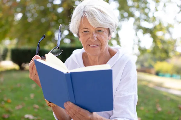 在公园看书的退休妇女 — 图库照片