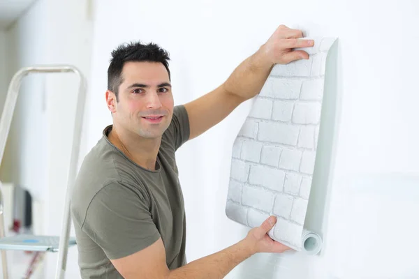 Man Unrolling Roll Brick Patterned Wallpaper — Stok fotoğraf