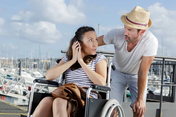 車椅子の男性と女性がスマートフォンを持っていて — ストック写真