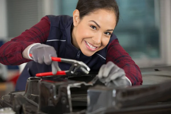 車の車体修理のためのペンチを使用して女性の機械工 — ストック写真