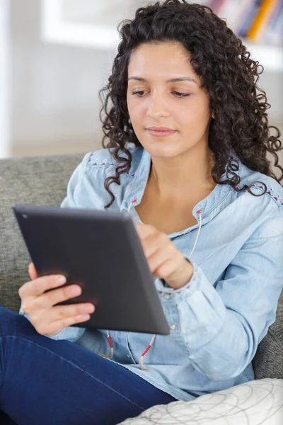 女人正在沙发上休息和阅读平板电脑 — 图库照片