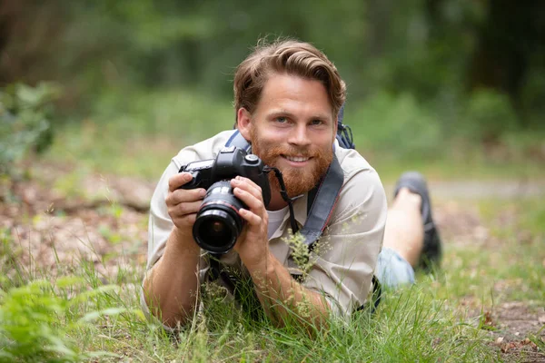 Jovem Fotógrafo Masculino Colocado Grama Segurando Câmera — Fotografia de Stock