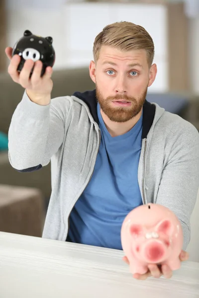 Man Holding Two Different Sized Piggybanks — Stock Photo, Image