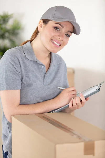 クリップボードを保持するパッケージを提供する幸せな女性 — ストック写真