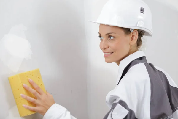 Kobieta Budowniczy Myje Ścianę — Zdjęcie stockowe