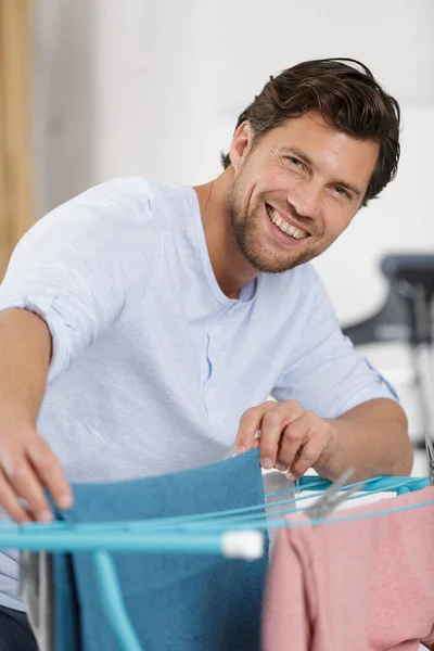 Homem Espalhando Lavagem Secador Interiores — Fotografia de Stock