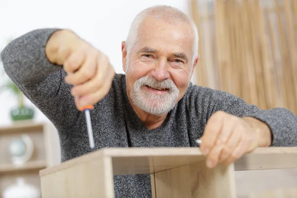 Glücklicher Senior Mit Schraube Und Möbeln — Stockfoto