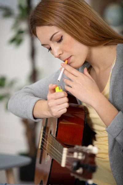 Kadın Evde Gitar Tutarken Sigara Içiyor — Stok fotoğraf