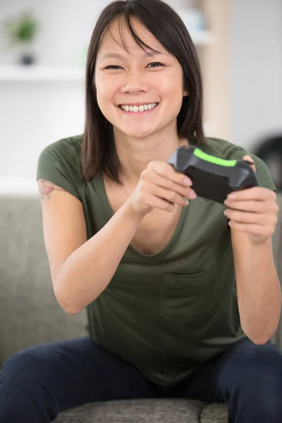 幸せなアジアの女性が家庭でビデオゲームをしています — ストック写真