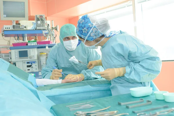 手术过程中与助手交谈的外科医生 — 图库照片