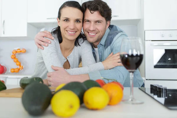 キッチンでワインを飲みながら抱きつくカップル — ストック写真