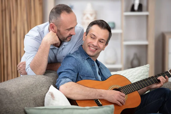 Evdeki Koltukta Oturan Gitarlı Eşcinsel Çift — Stok fotoğraf