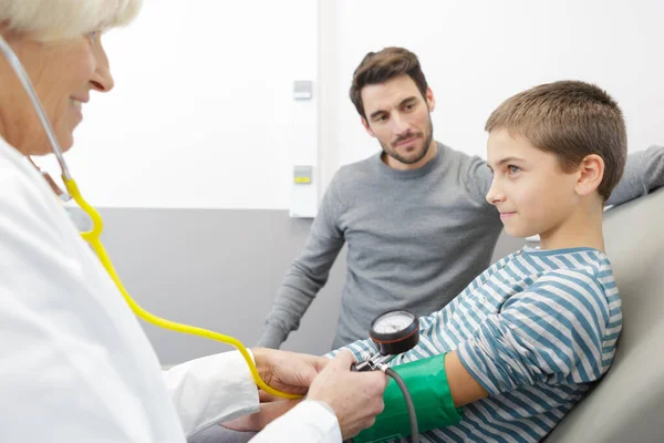小さな男の子が血圧を測定している病院の医師を訪ね — ストック写真