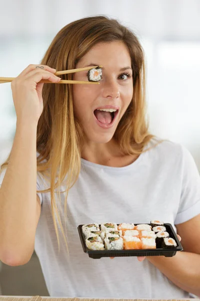 Leende Ung Kvinna Som Håller Sushi Framför Ögonen — Stockfoto