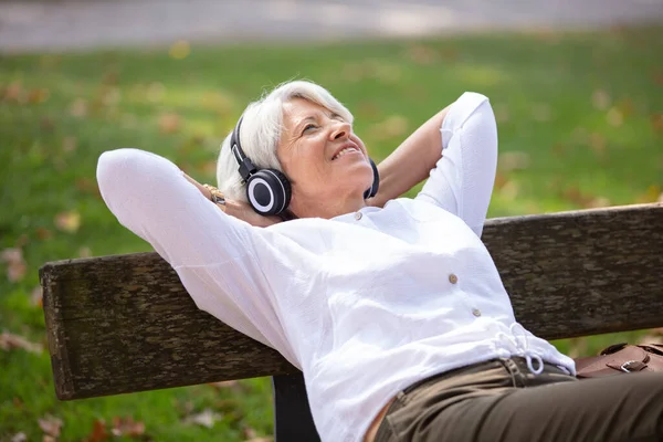Усміхнений Старший Сидить Лавці Парку Слухаючи Музику — стокове фото