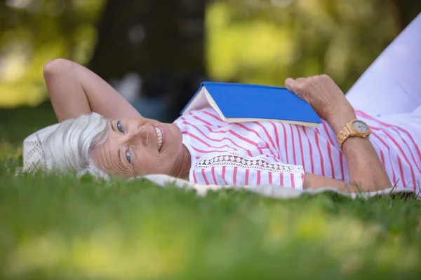 Senior Vrouw Lezen Boek Gelegd Het Gras — Stockfoto
