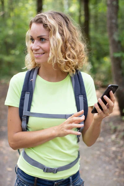 Jovem Mulher Usando Telefone Inteligente Durante Caminhada Floresta — Fotografia de Stock