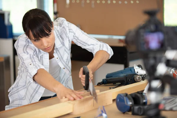 木材に電気サンダーを使う女性大工 — ストック写真