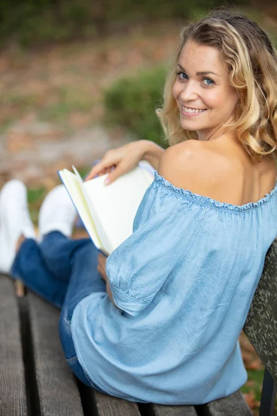 在公园长椅上看书的女人 — 图库照片